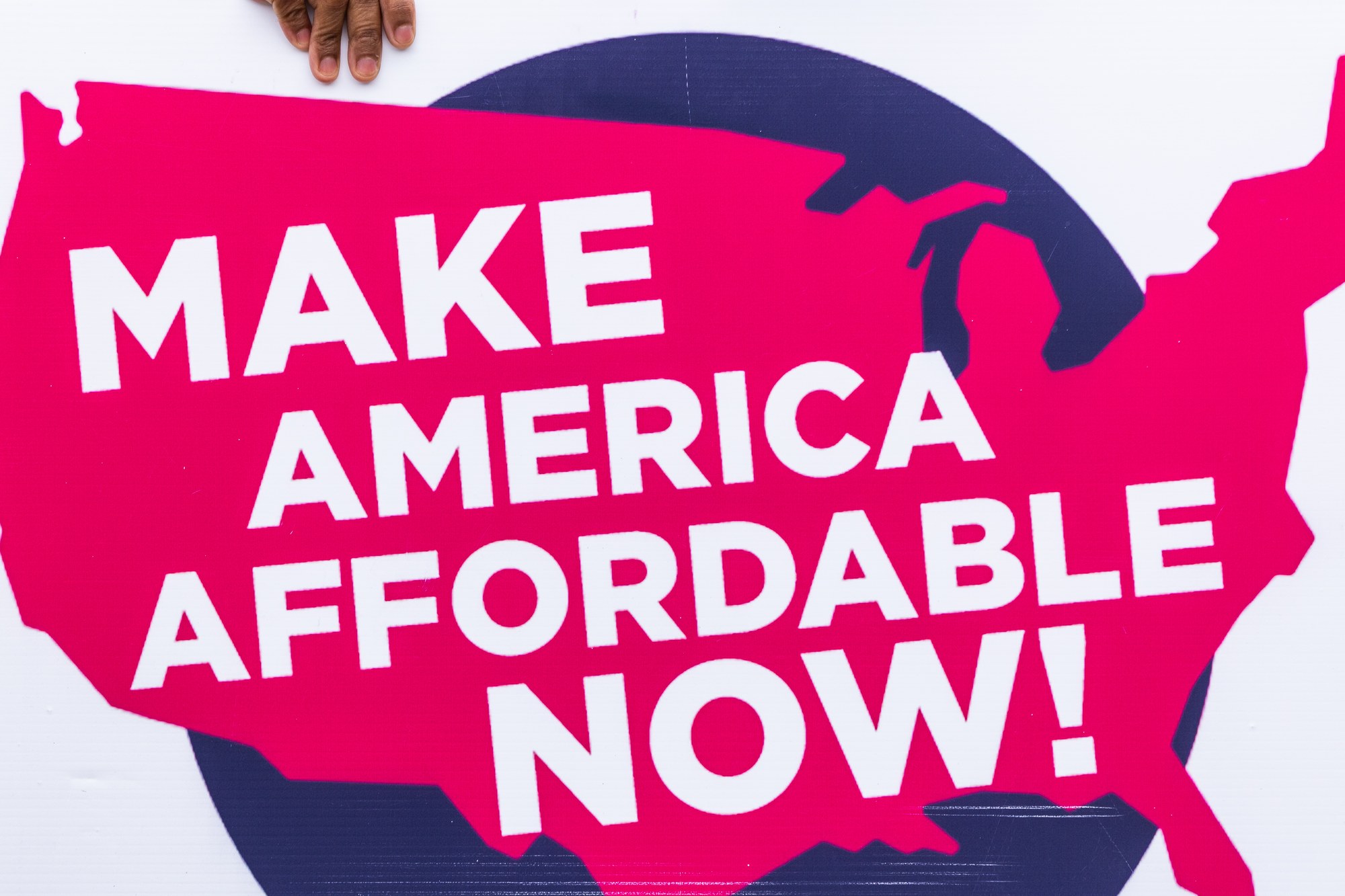 A protest sign reading Make America Affordable Now at the federal Living Wage For All Act launch