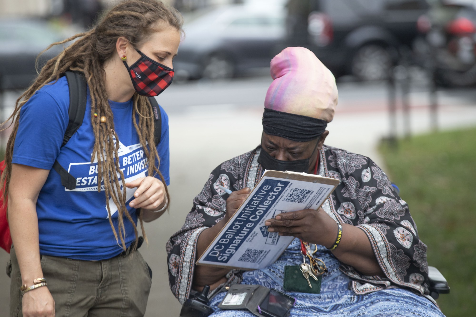 An OFW organizer helps a D.C. resident sign the Initiative 82 ballot petition during the original I-82 campaign