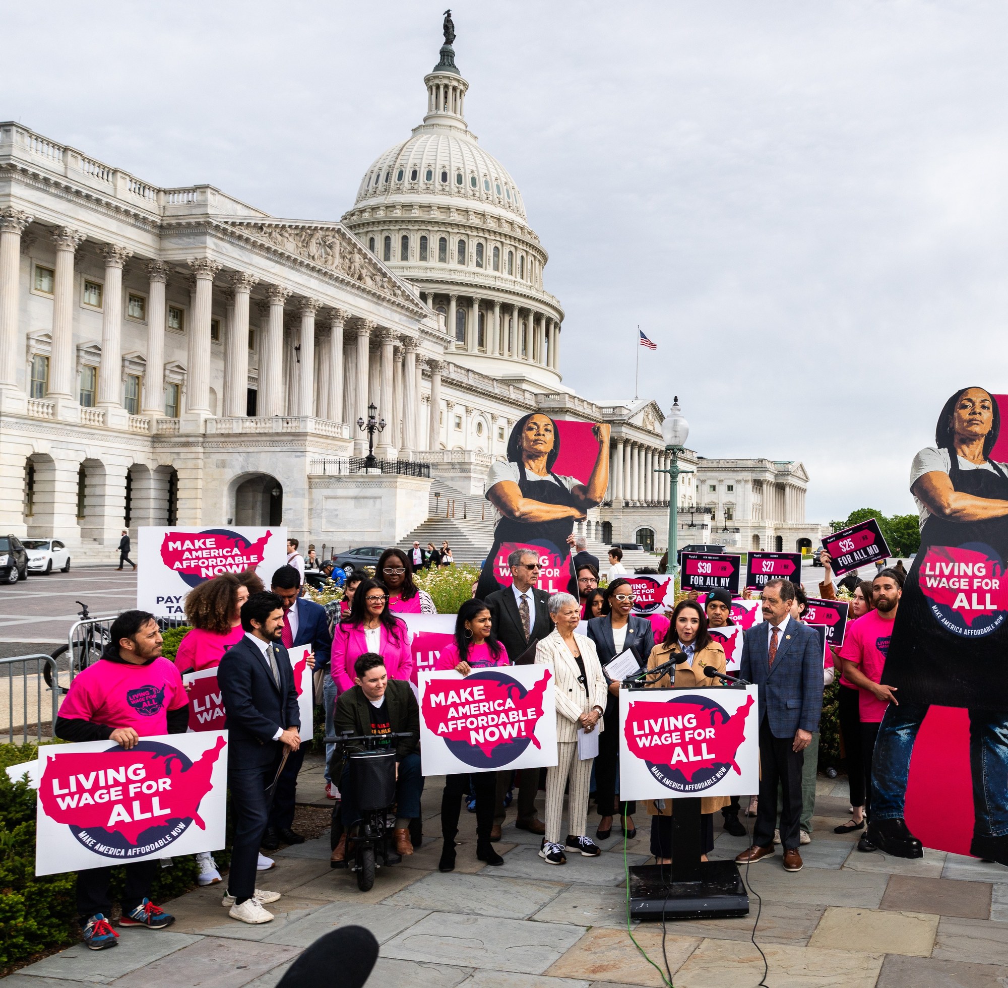 One Fair Wage members in pink OFW shirts holding Living Wage For All signs at the U.S. Capitol