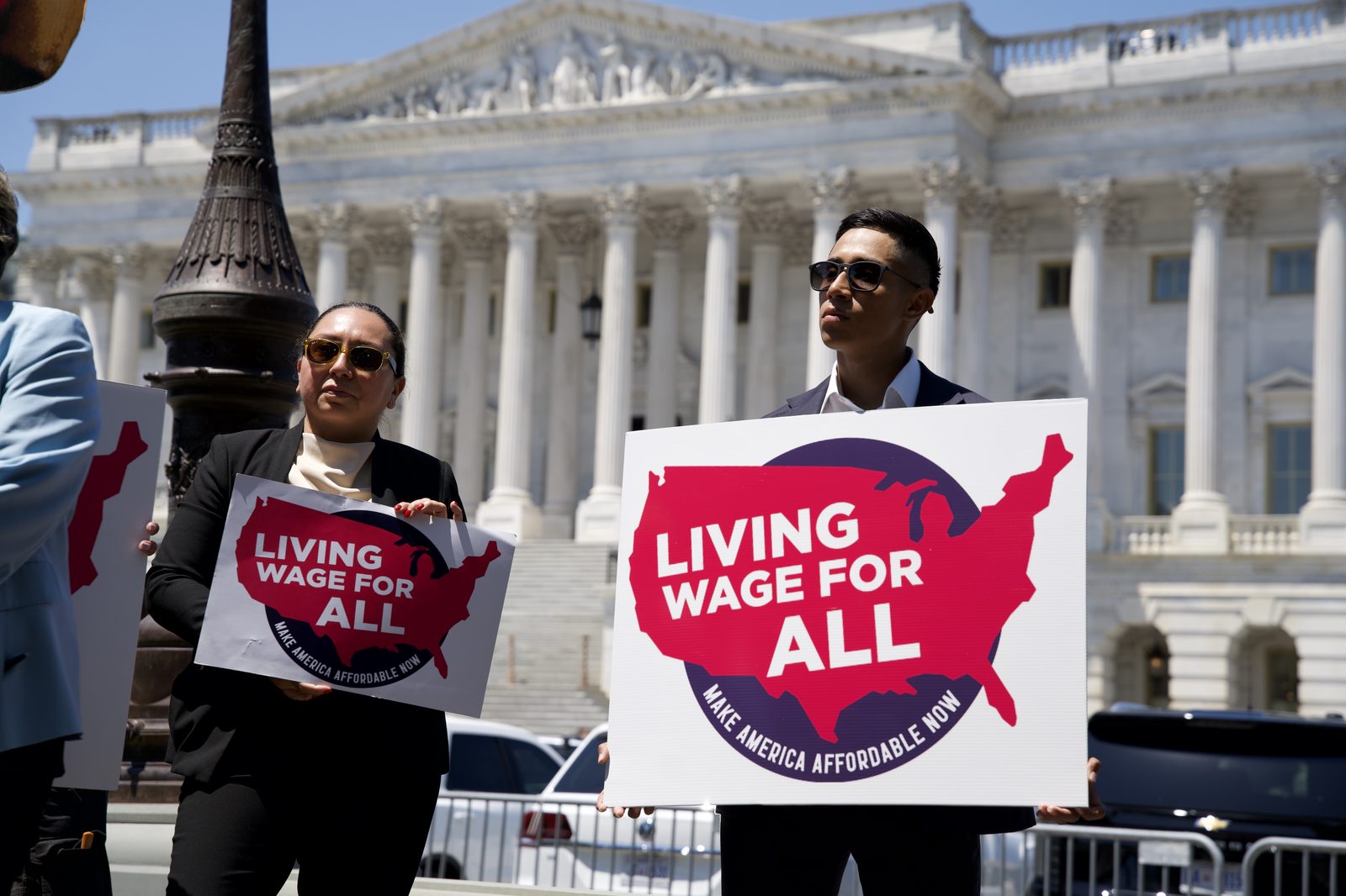 Coalition member holds a Living Wage For All sign in front of the U.S. Capitol at the Senate launch of the Living Wage For All Act, June 25, 2026
